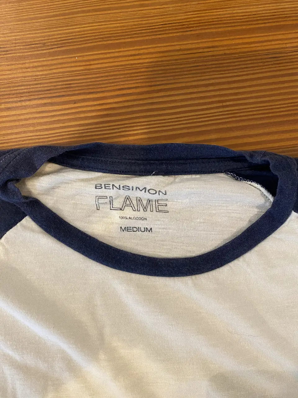 Remera manga corta de hombre, de algodón, con cuello redondo y mangas en color azul marino. La remera es de color blanco con mangas azules. Ideal para un look casual y cómodo.