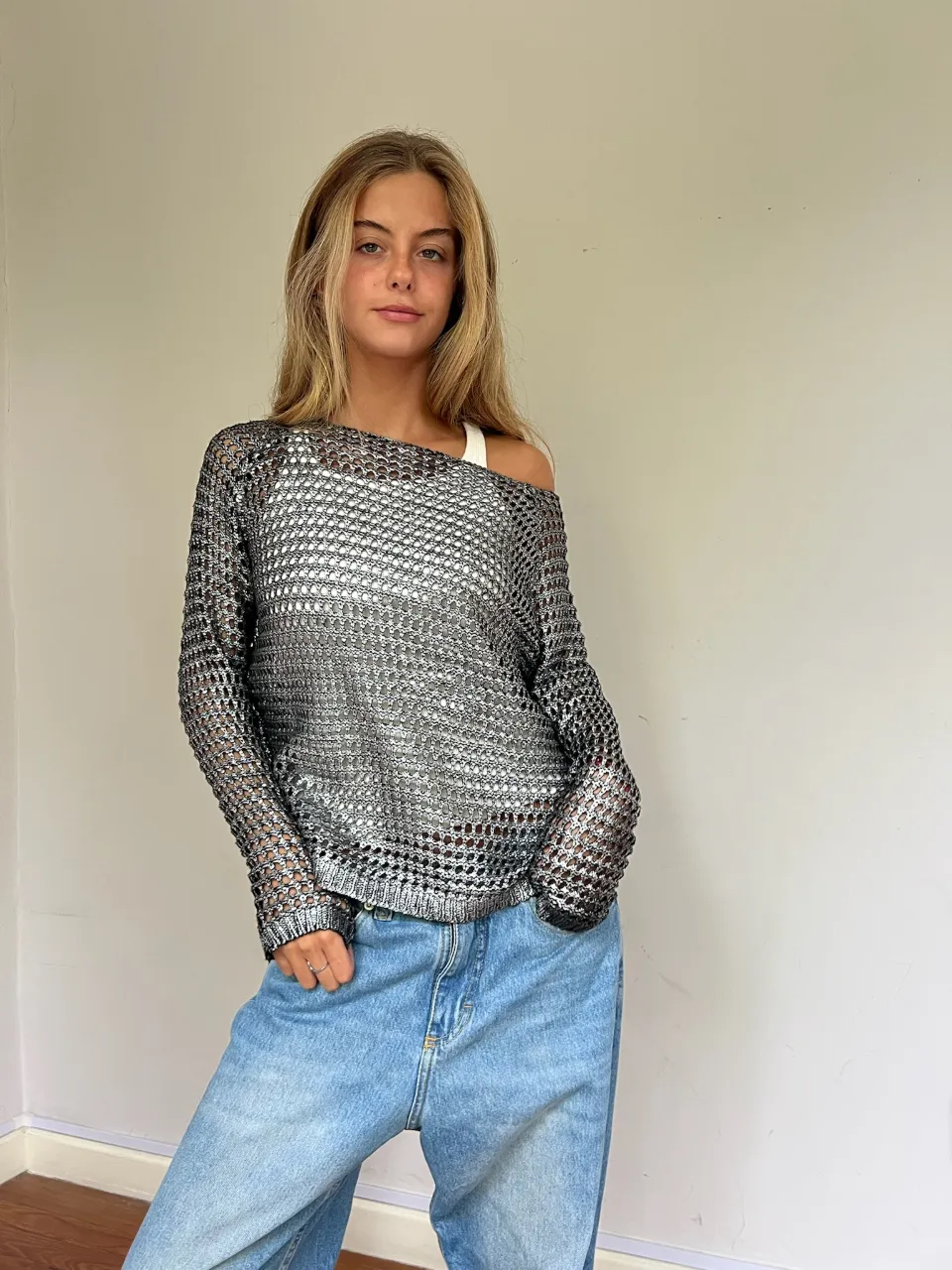 Sweater plateado de tejido abierto con mangas largas y cuello redondo. 