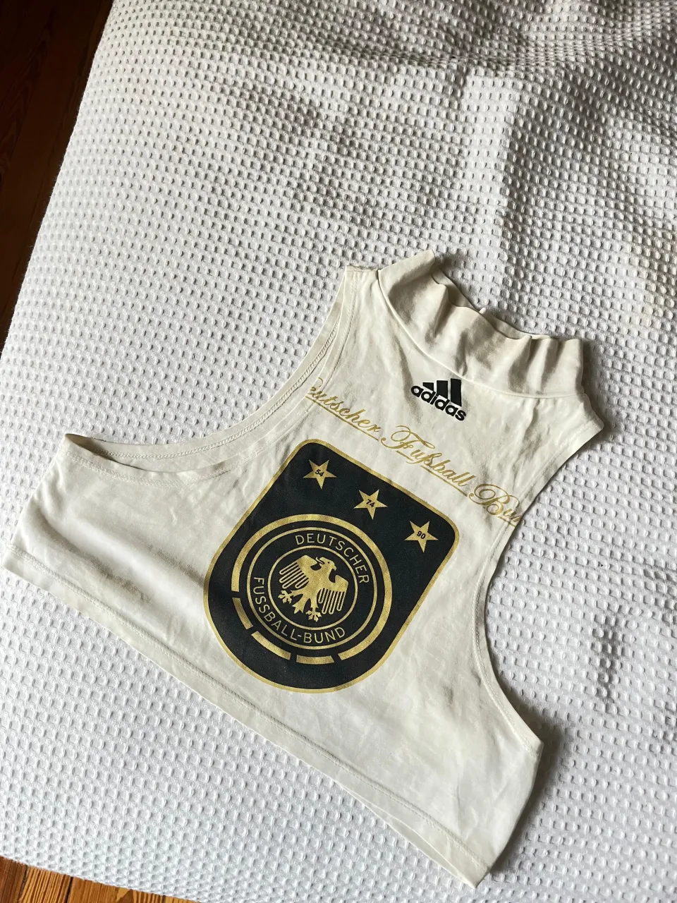 Musculosa blanca con escudo de la selección alemana de fútbol y logo de Adidas.