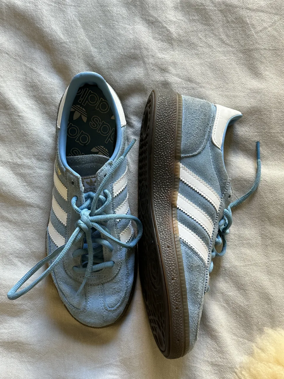 Zapatillas spezial adidas de gamuza color azul claro con detalles blancos y cordones a tono. La suela es de goma oscura.