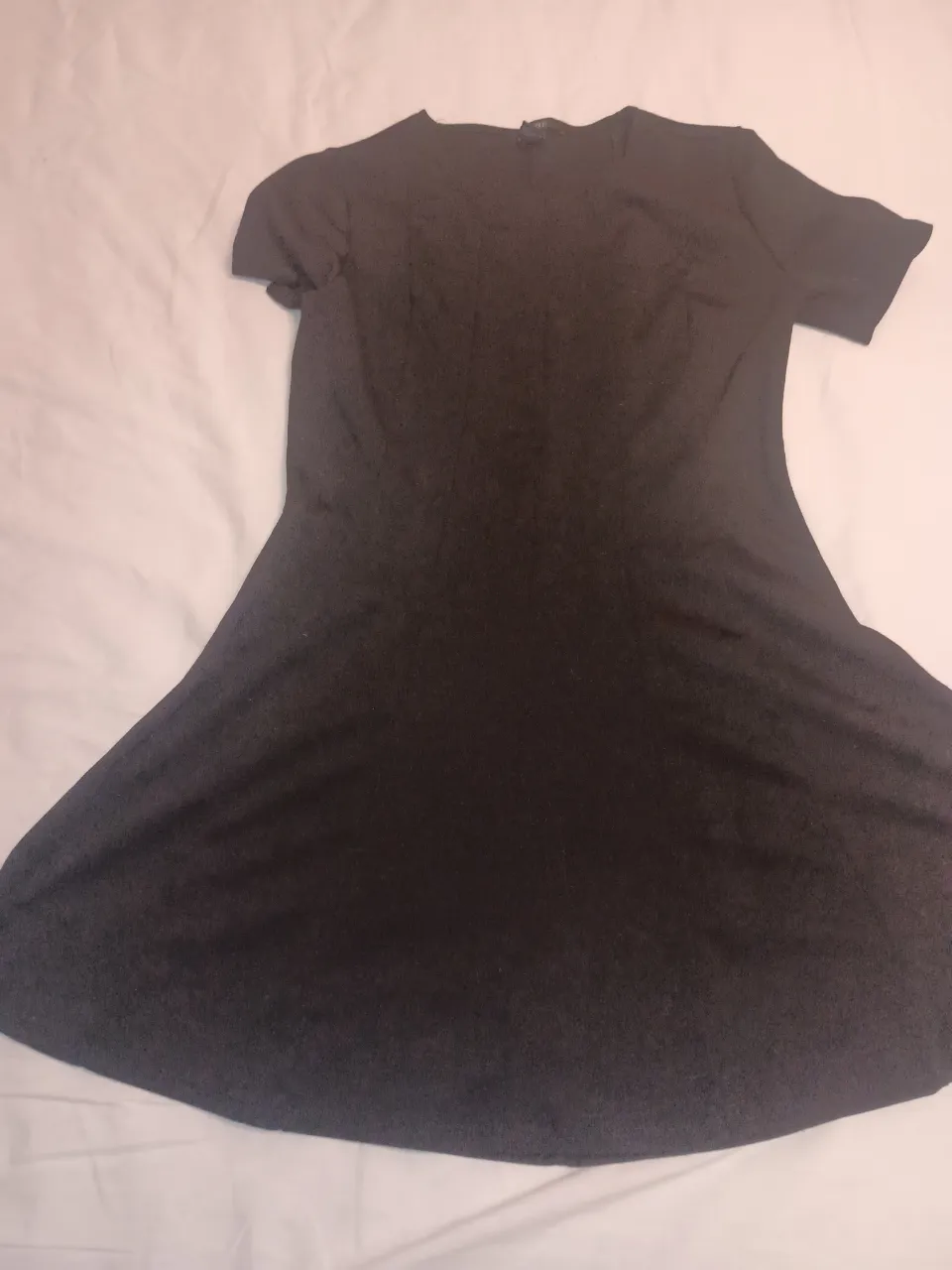 Vestido negro de manga corta y cuello redondo.