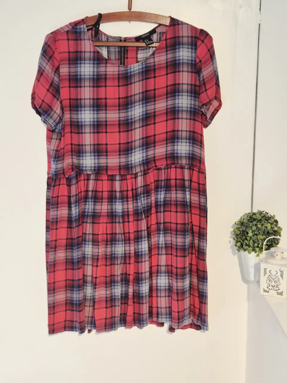 Vestido midi de Forever 21 con estampado a cuadros en tonos rojos, azules y grises. Corte holgado con fruncido en la cintura y mangas cortas. Ideal para un look casual y fresco.
