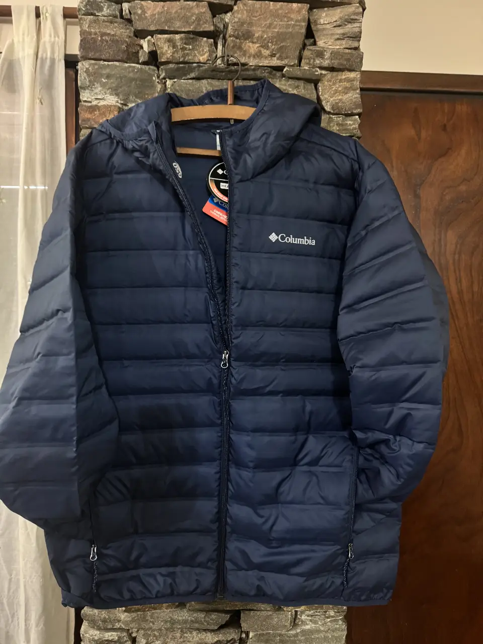 Campera Columbia azul marino con capucha, ideal para el invierno. Cuenta con cierre completo, bolsillos y el logo de la marca. Perfecta para mantenerte abrigado y cómodo en cualquier ocasión.