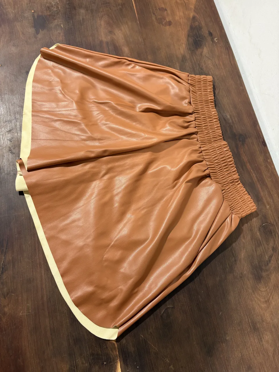 Shorts de cuero sintético color marrón, con cintura elastizada y detalles en los bordes. Ideales para un look canchero y moderno.