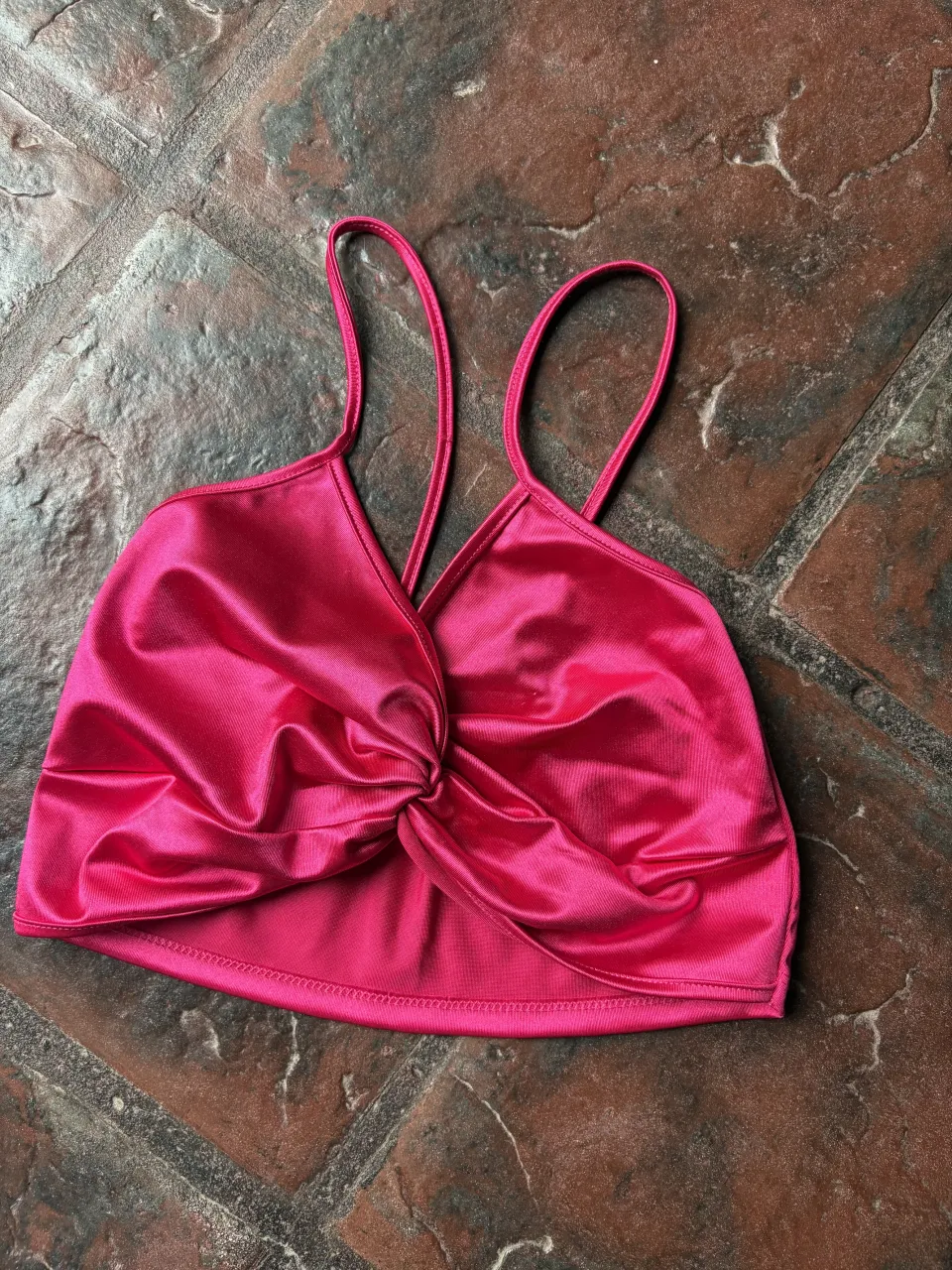 Top rosa fucsia con torzado en el frente. Breteles finos y escote en V. Ideal para un look canchero y moderno.