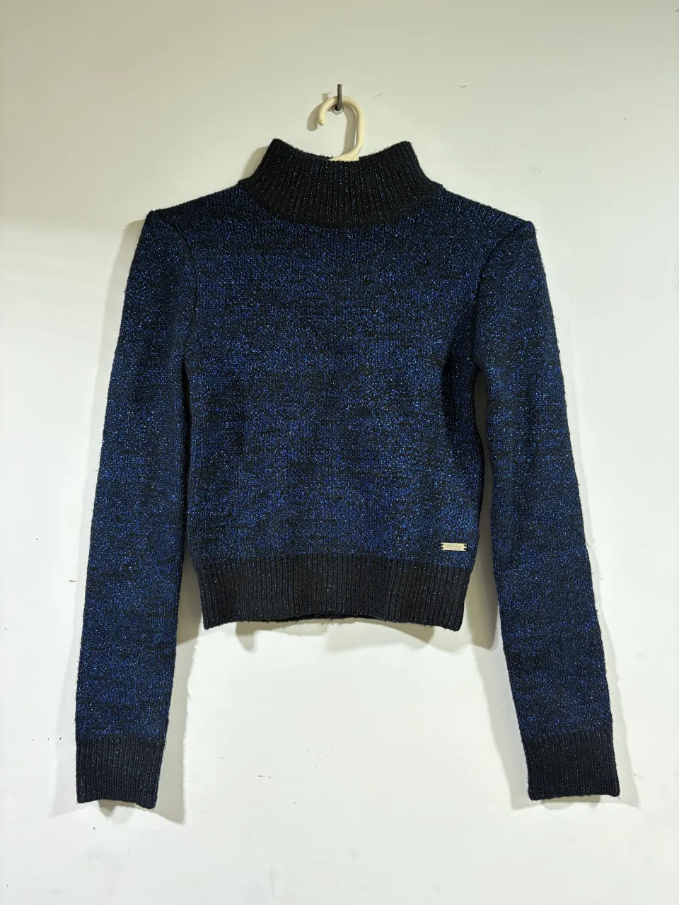 Sweater de cuello alto con brillos en tono azul y negro. Un básico ideal para lucir canchera en cualquier ocasión.