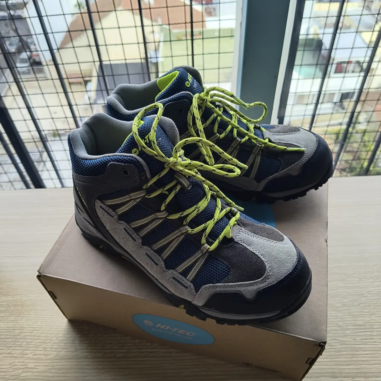 Botas de trekking Hi-Tec Forza Mid WP Jr, impermeables, con cordones amarillos y detalles en gris y azul. Ideales para actividades al aire libre.