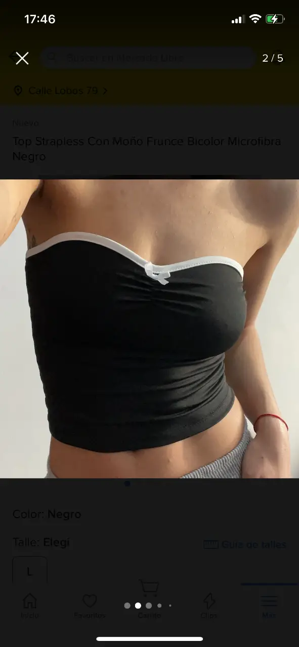 Top strapless bando negro con detalle de moño y borde blanco. Ideal para un look moderno y versátil.