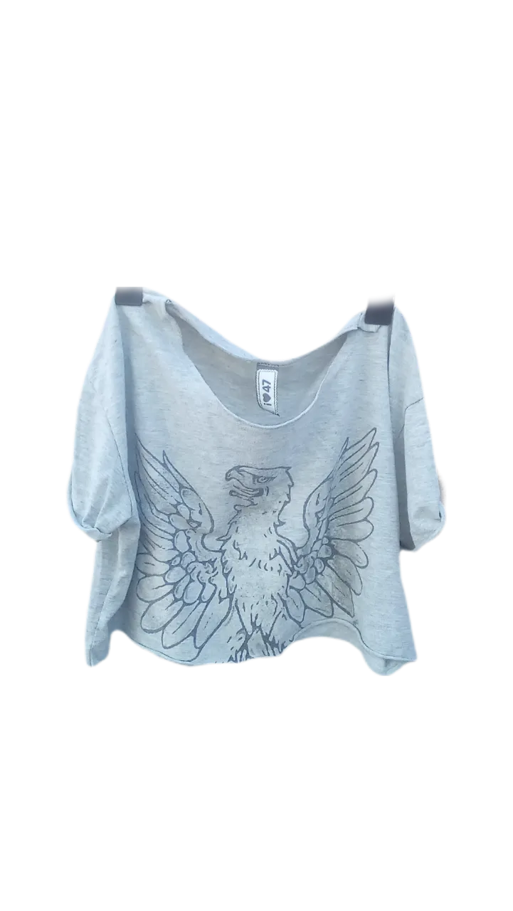 Remera gris clara con estampa de águila en el frente. Cuello redondo y mangas cortas.