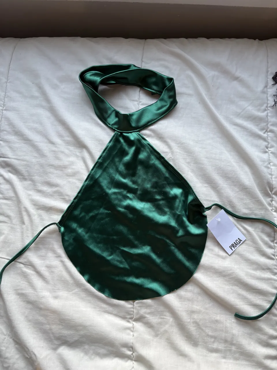 Top de seda verde con cuello halter y tiras para atar en la espalda. 
