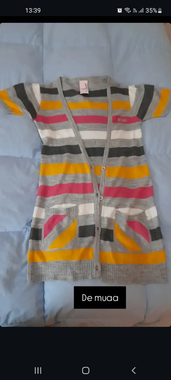 Sweter de mujer a rayas horizontales en tonos grises, amarillos, rosas y blancos. Con bolsillos delanteros y botones.