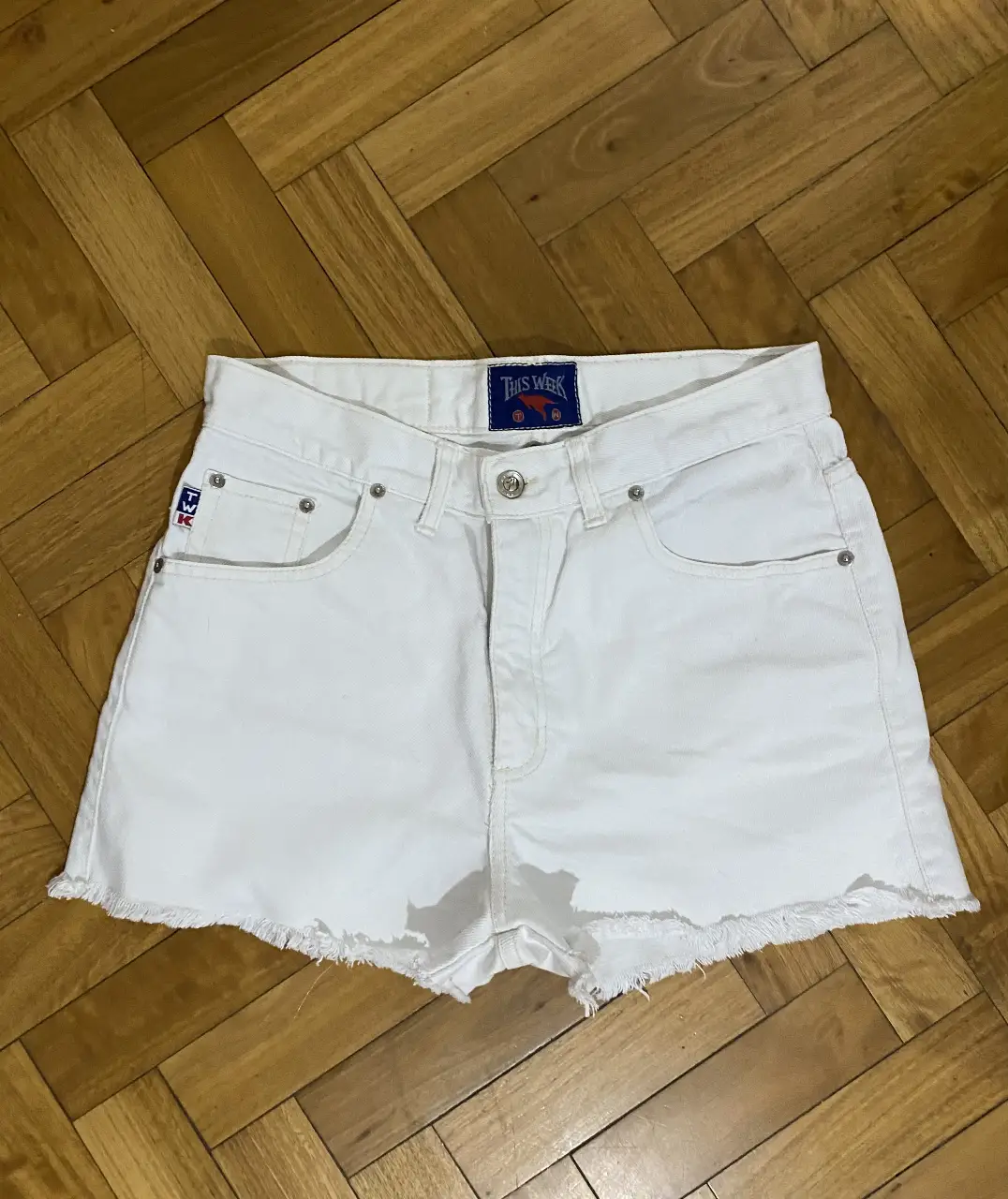Short de jean blanco de tiro alto con detalles desflecados. Ideal para un look casual y fresco.