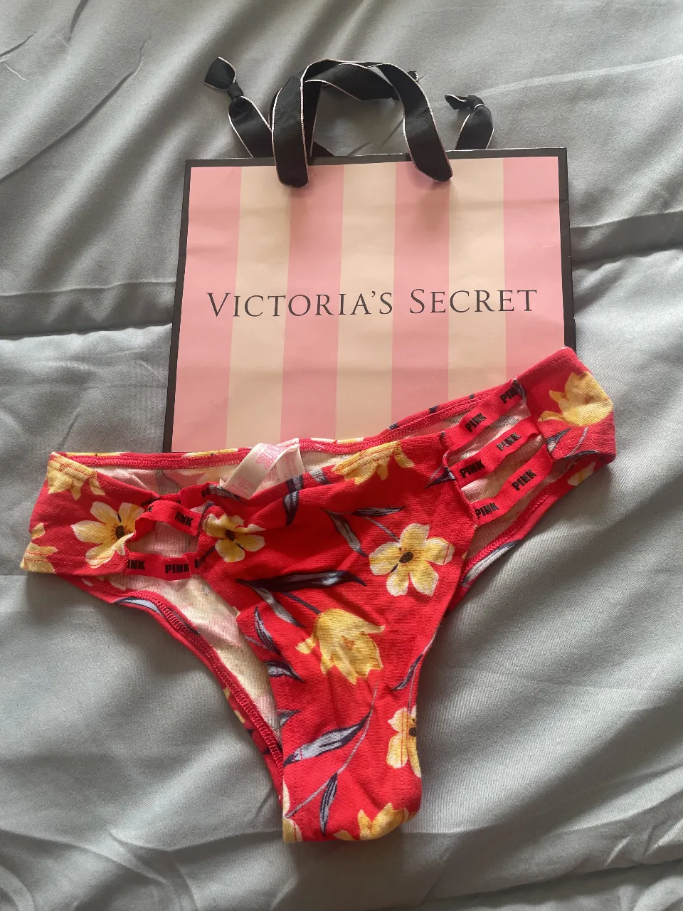 Bombacha de mujer de la marca PINK, con estampado floral en tonos rojos y amarillos. Talle XS. Ideal para uso diario.