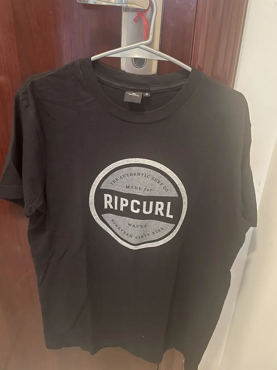 Remera negra de hombre Rip Curl con estampado en el pecho. Talle S. Ideal para un look casual y relajado.