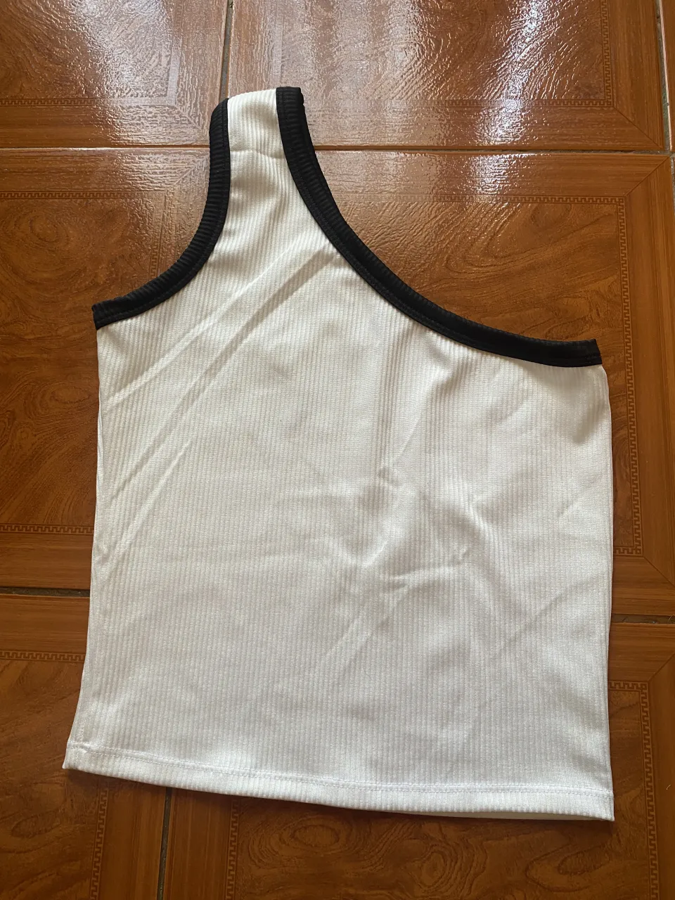 Musculosa blanca con borde negro y musculosa roja con borde blanco. Ambas son de un solo hombro.
El precio es por AMBAS!