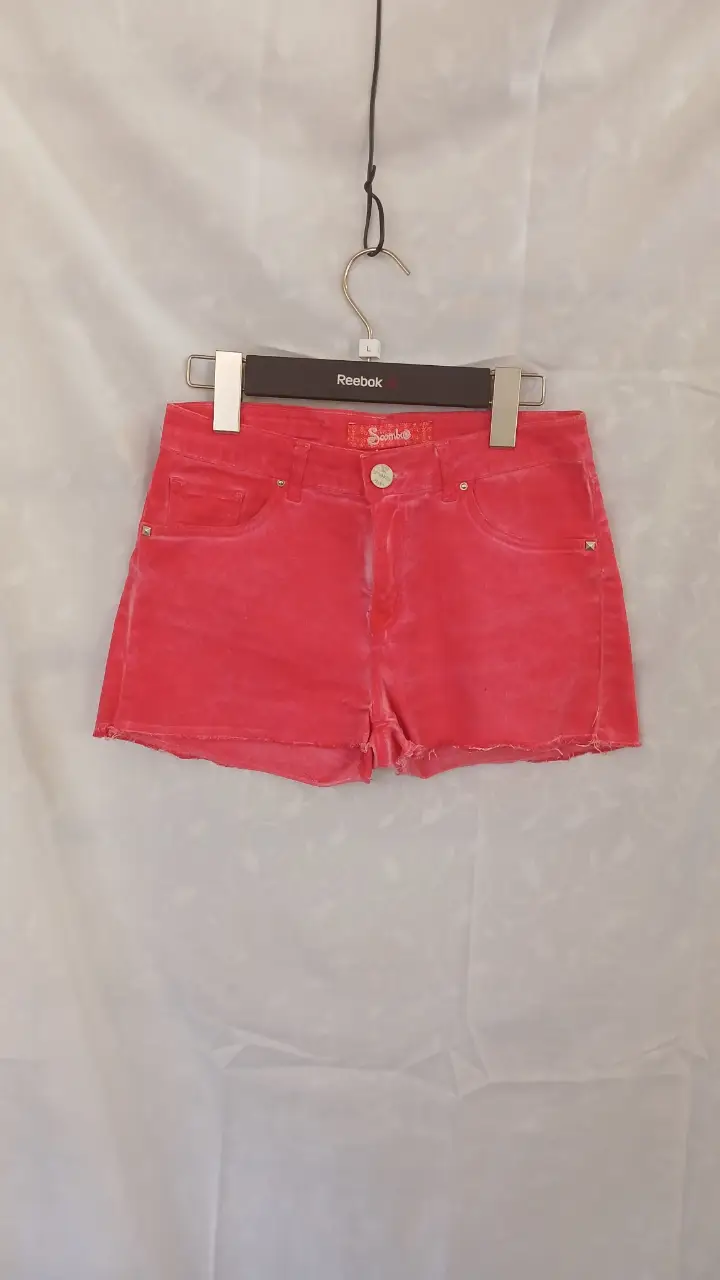 Short de jean de scombro, color salmon, tiro medio, con detalles de desgaste y bolsillos. talle 26
