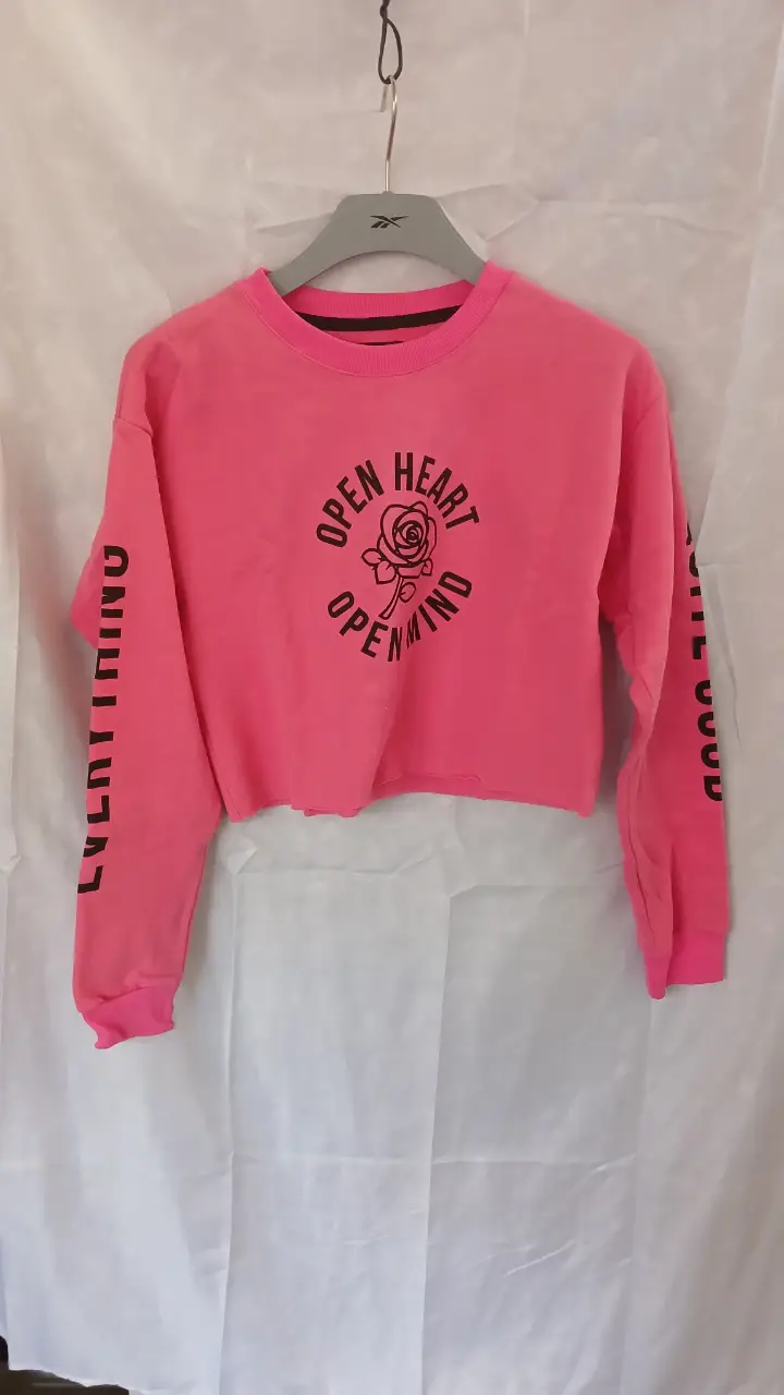 Buzo crop rosa con estampado "OPEN HEART OPEN MIND" y detalles en negro. Manga larga con frase "EVERYTHING IS GOOD" en cada manga. Talle 38. Polar