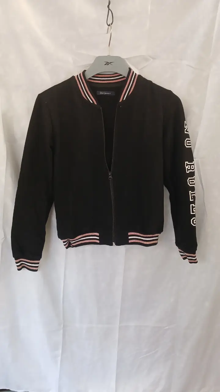 Campera bomber negra con detalles en rosa y blanco. Tiene cierre frontal y detalles en las mangas. Ideal para un look casual y deportivo. Tiene polar es abrigada