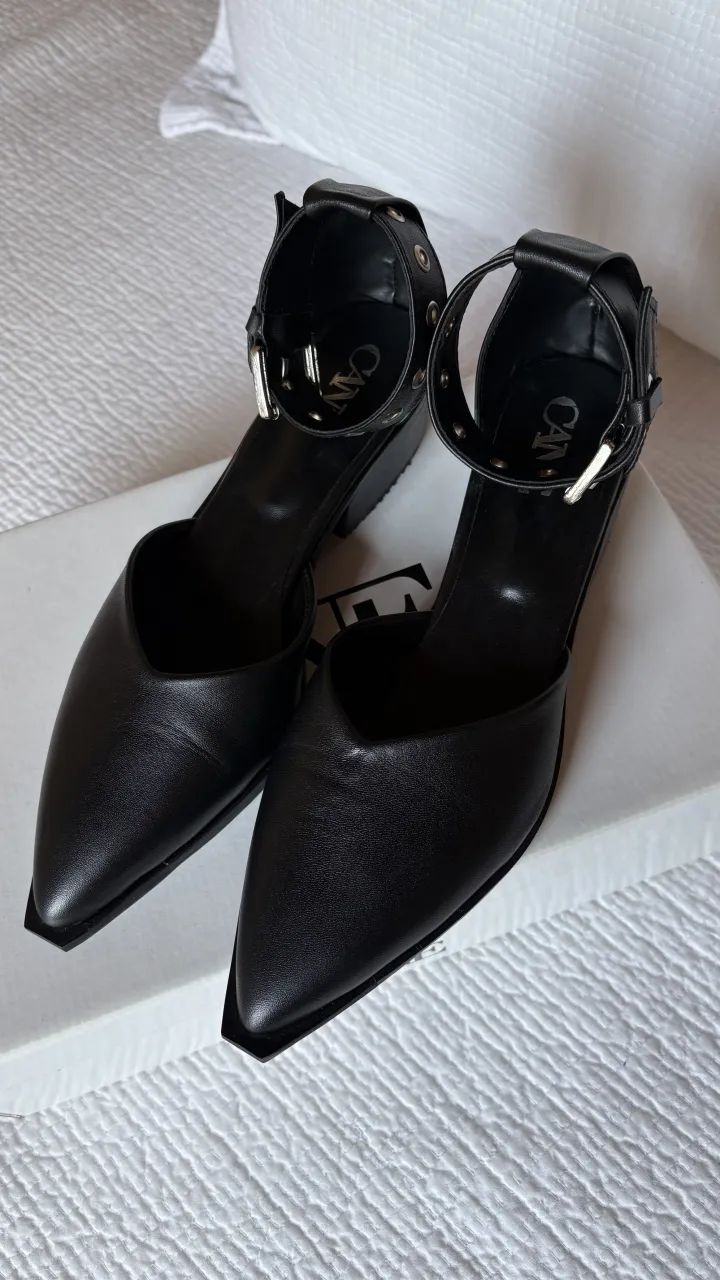 Zapatos negros de taco bajo con tiras al tobillo y hebilla. Punta fina y diseño moderno, ideales para un look elegante y con onda. Horma chica, son talle 37, pero van mejor para un 36.