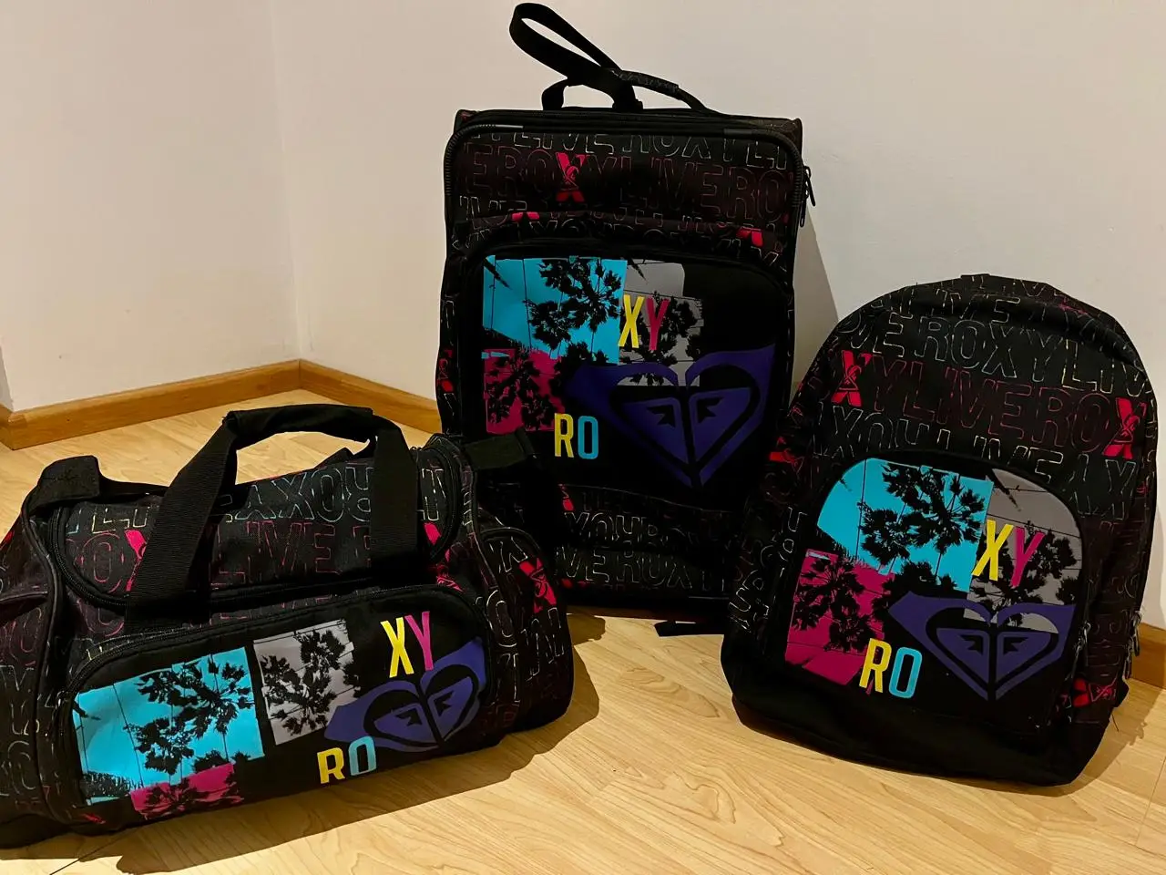 Set de bolsos deportivos Roxy, ideal para llevar todo lo necesario con estilo. Incluye un bolso de mano, una mochila y un bolso con ruedas, todos con el icónico diseño Roxy. Perfecto para viajes, gimnasio o actividades al aire libre.