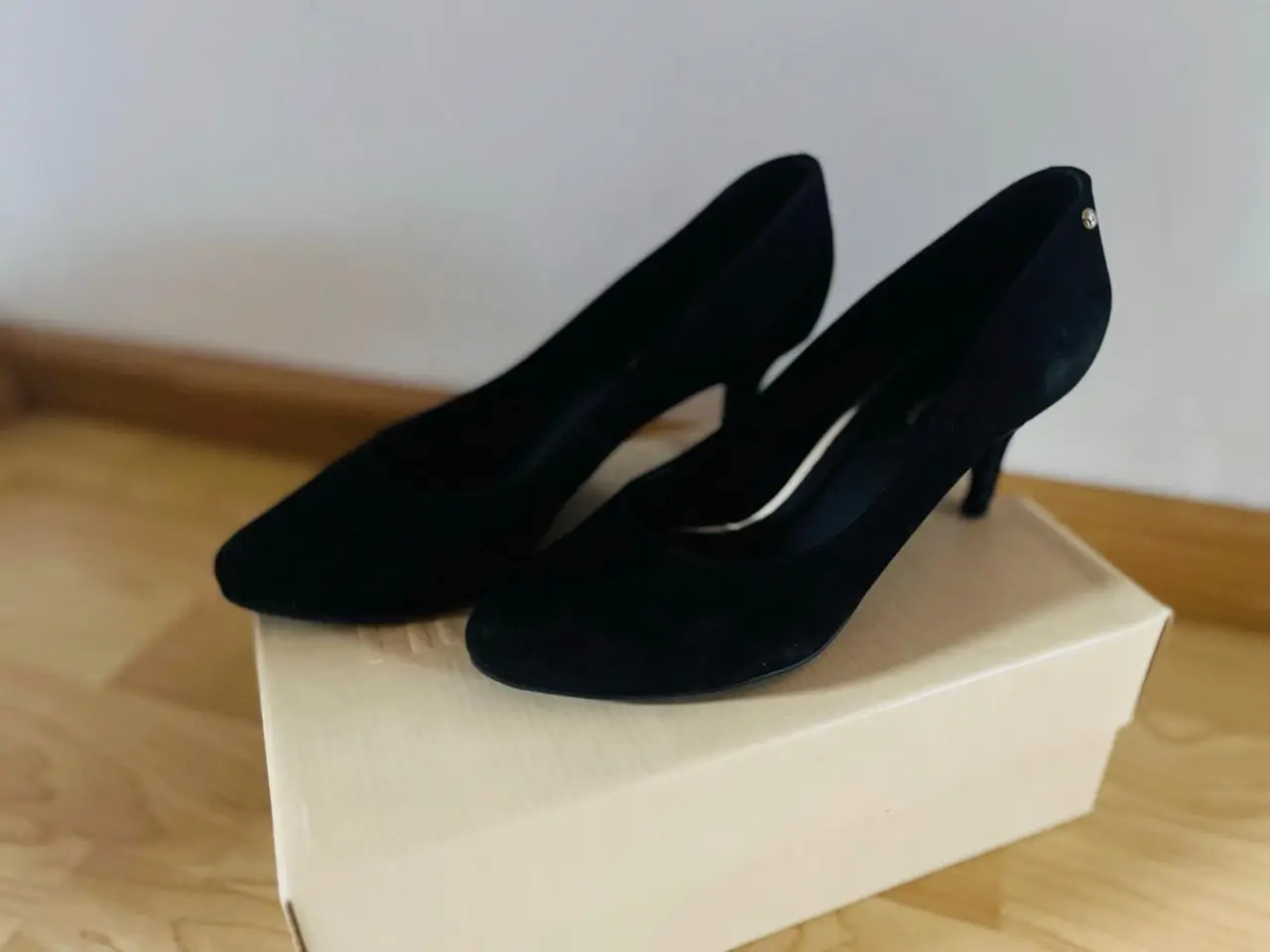 Elegantes zapatos de tacón negro de gamuza, ideales para ocasiones formales y fiestas. Diseño clásico y sofisticado.