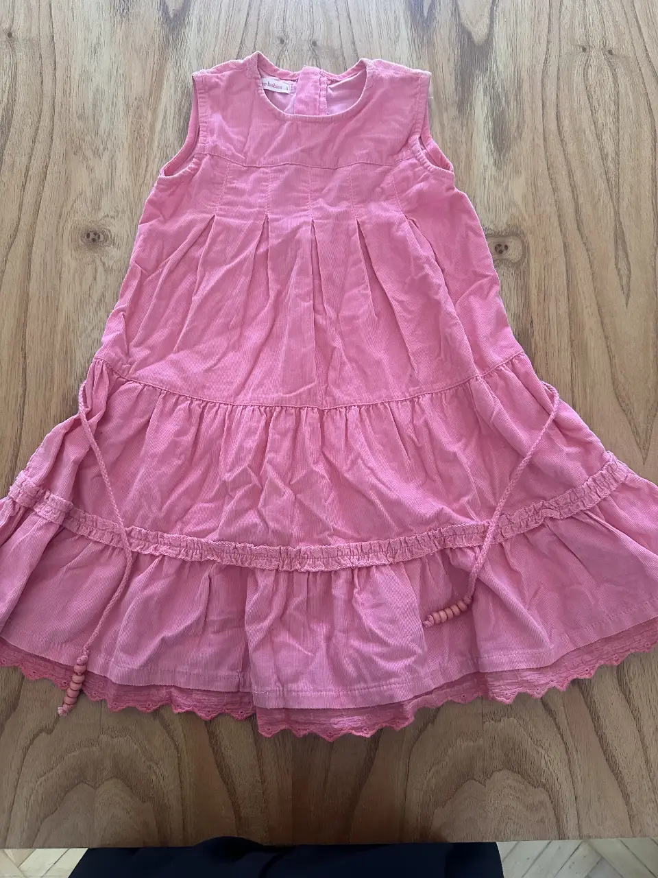 Vestido mini rosa de corderoy, ideal para un look casual y cómodo. Con detalles de volados y un diseño delicado.