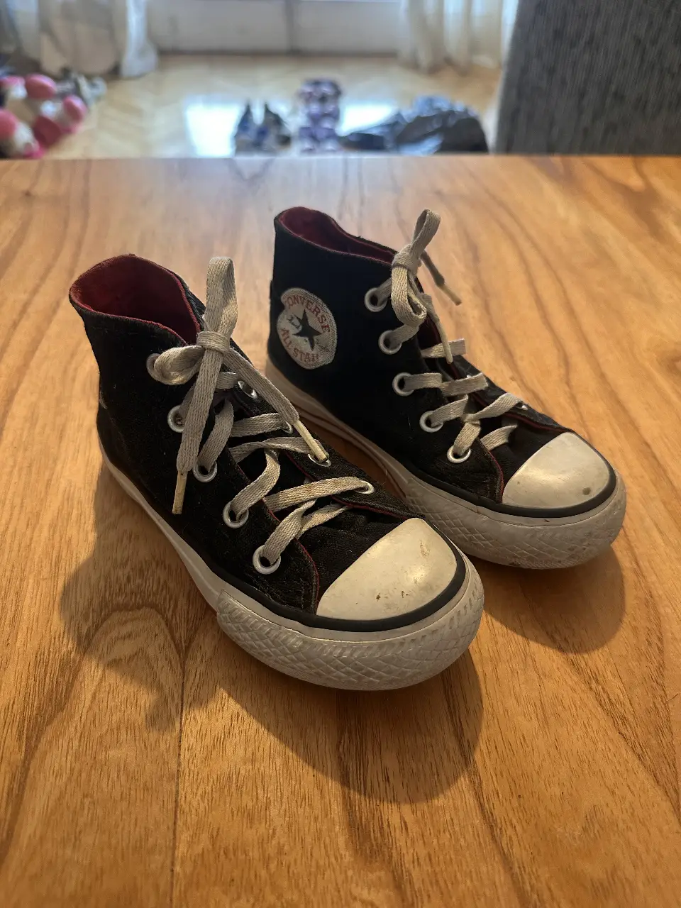 Zapatillas Converse All Star negras de caña alta, para niños, con puntera blanca y detalles en rojo en el interior. Un clásico atemporal para un look casual y urbano.