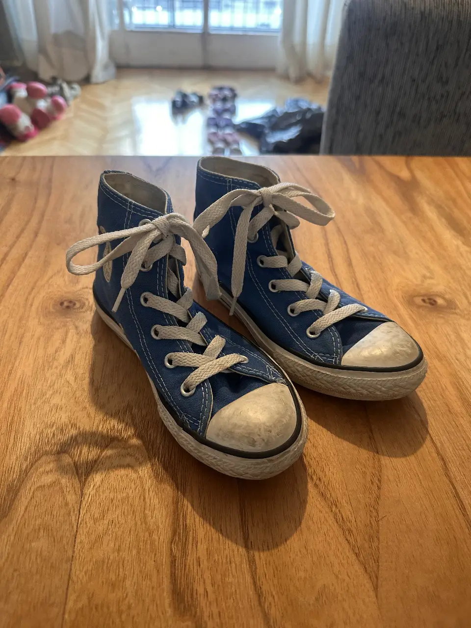Zapatillas Converse azules de lona, estilo botita, con cordones blancos y puntera reforzada. Ideales para un look casual y urbano.