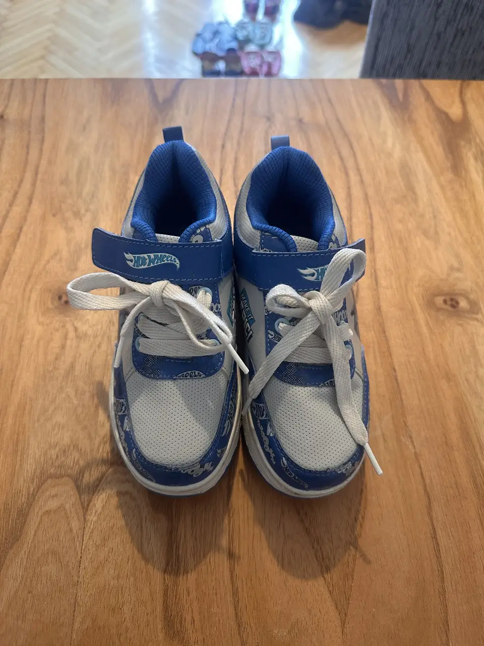 Zapatillas para niños con diseño de Hot Wheels. Color azul y blanco, con cierre de velcro y cordones. Ideales para uso diario y actividades deportivas.