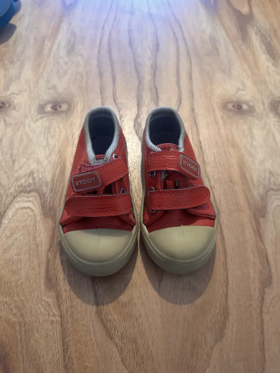 Zapatillas rojas para niños con cierre de velcro y puntera beige. Ideales para un look casual y cómodo.