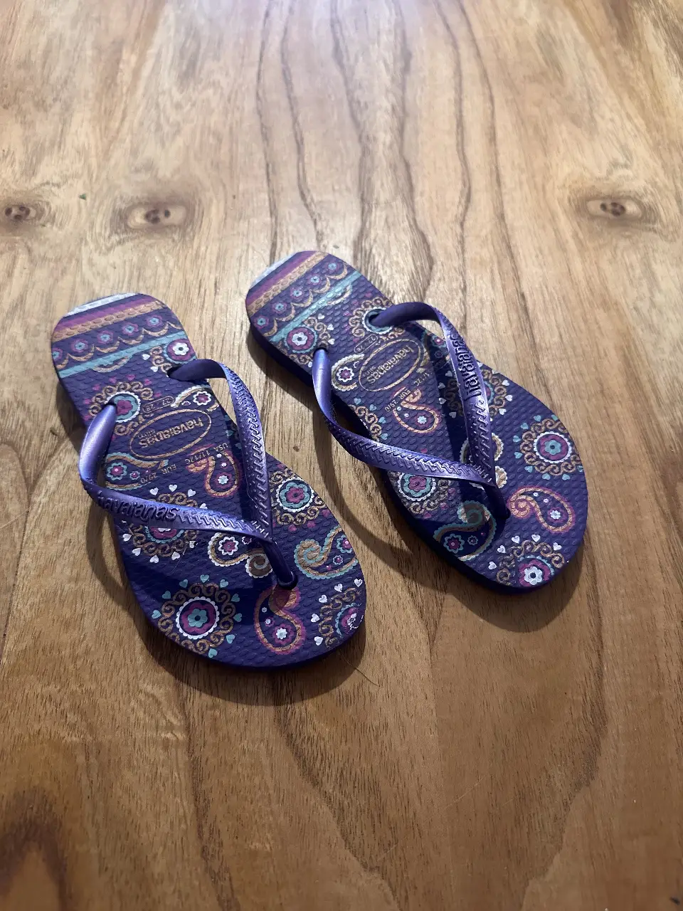Ojotas Havaianas con estampado paisley en tonos violetas y detalles en la suela. Ideales para un look casual y playero. Niña
