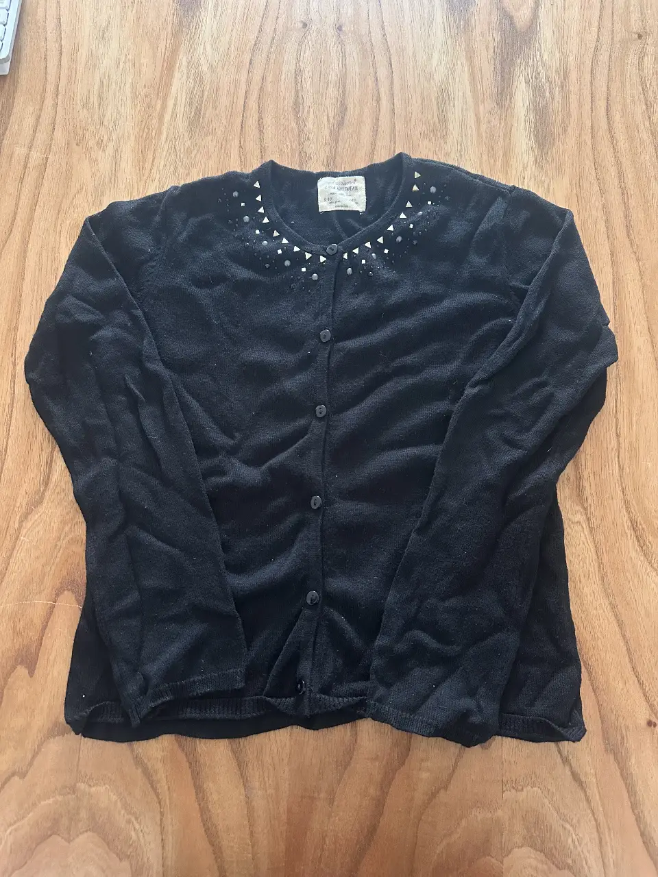 Cardigan negro de nena con detalles de brillos en el cuello. Ideal para un look casual o para complementar un outfit más formal.
