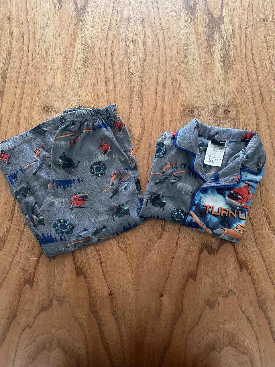 Pijama de niño con estampado de aviones de la película "Aviones". Incluye pantalón y camisa con botones, ideal para un descanso cómodo y divertido.