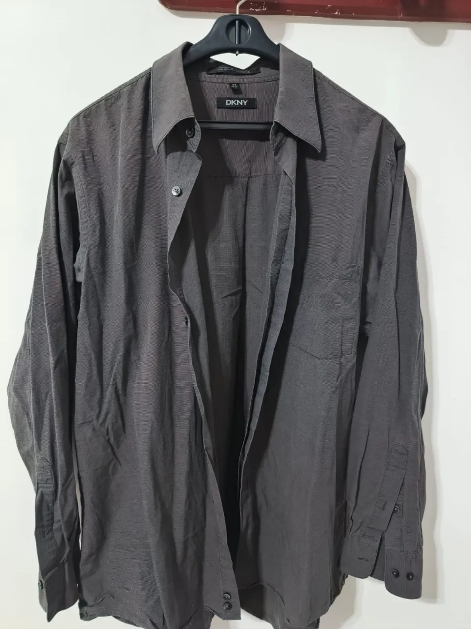 Camisa DKNY de hombre, manga larga, a rayas finas, color gris oscuro. Ideal para un look casual o de trabajo.