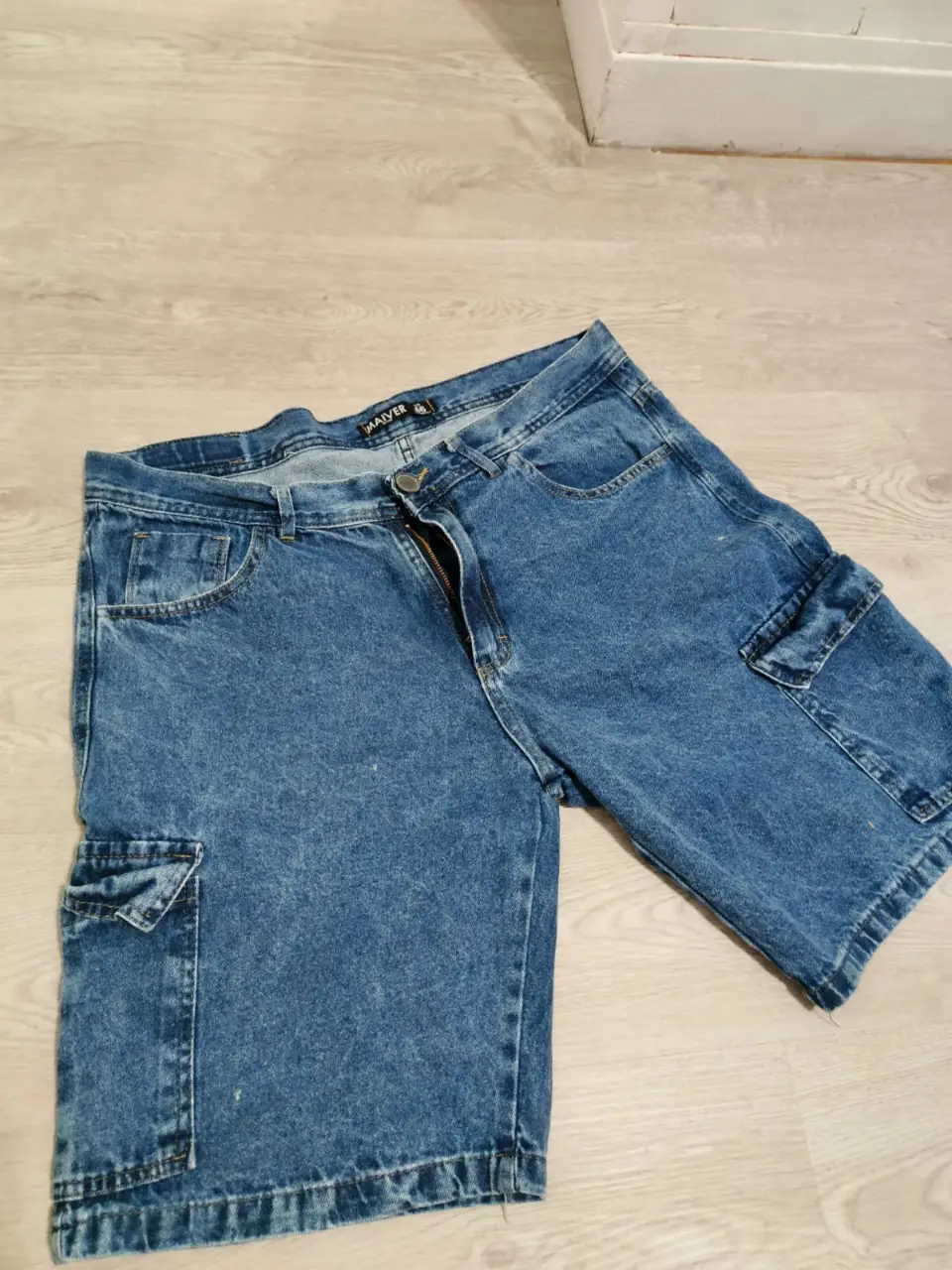 Short de jean de hombre, color azul gastado, con bolsillos cargo a los costados. Talle 46.