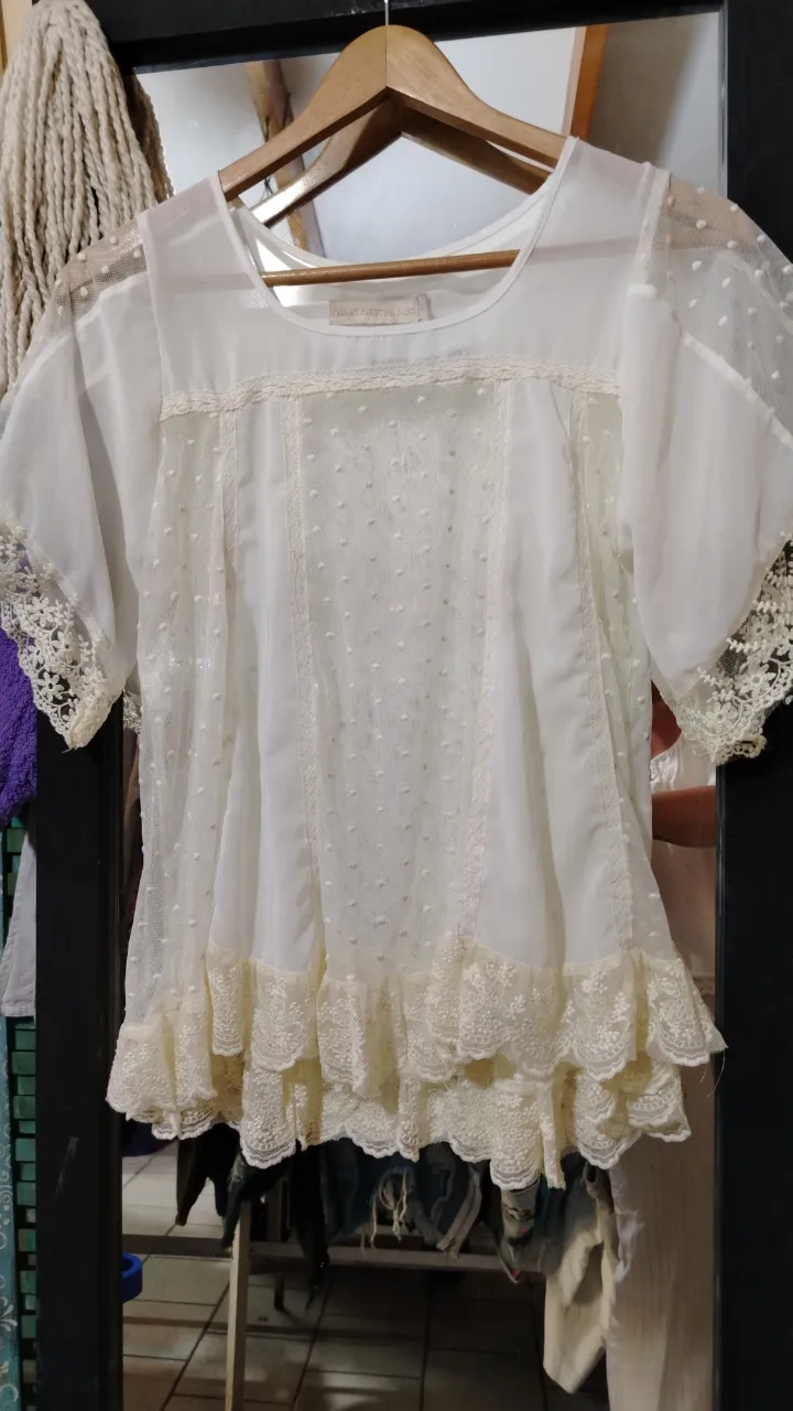 Blusa blanca de encaje con detalles de puntillas y volados. Mangas cortas con terminación de encaje. Ideal para un look romántico y delicado.

Medidas: 34cm de hombro a hombro, 54cm de axila axila, 23cm largo de manga,) 60cm largo total