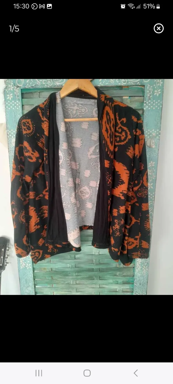 Cardigan de mujer con estampado abstracto en tonos naranja y negro. De la marca Basement Collection, con talle M. Ideal para usar en otoño.