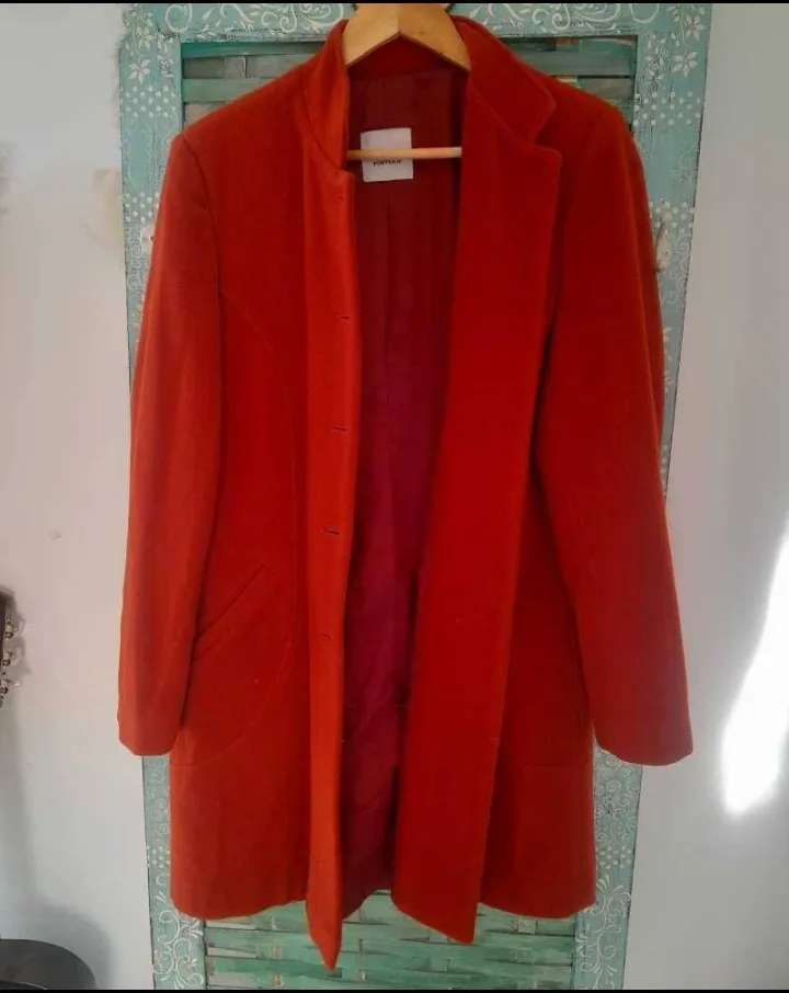 Tapado largo de paño color rojo, con cuello solapa y cierre con botones. Ideal para el invierno. Tien un detalle en la parte de abajo del forro del lado de adentro. x eso el precio 