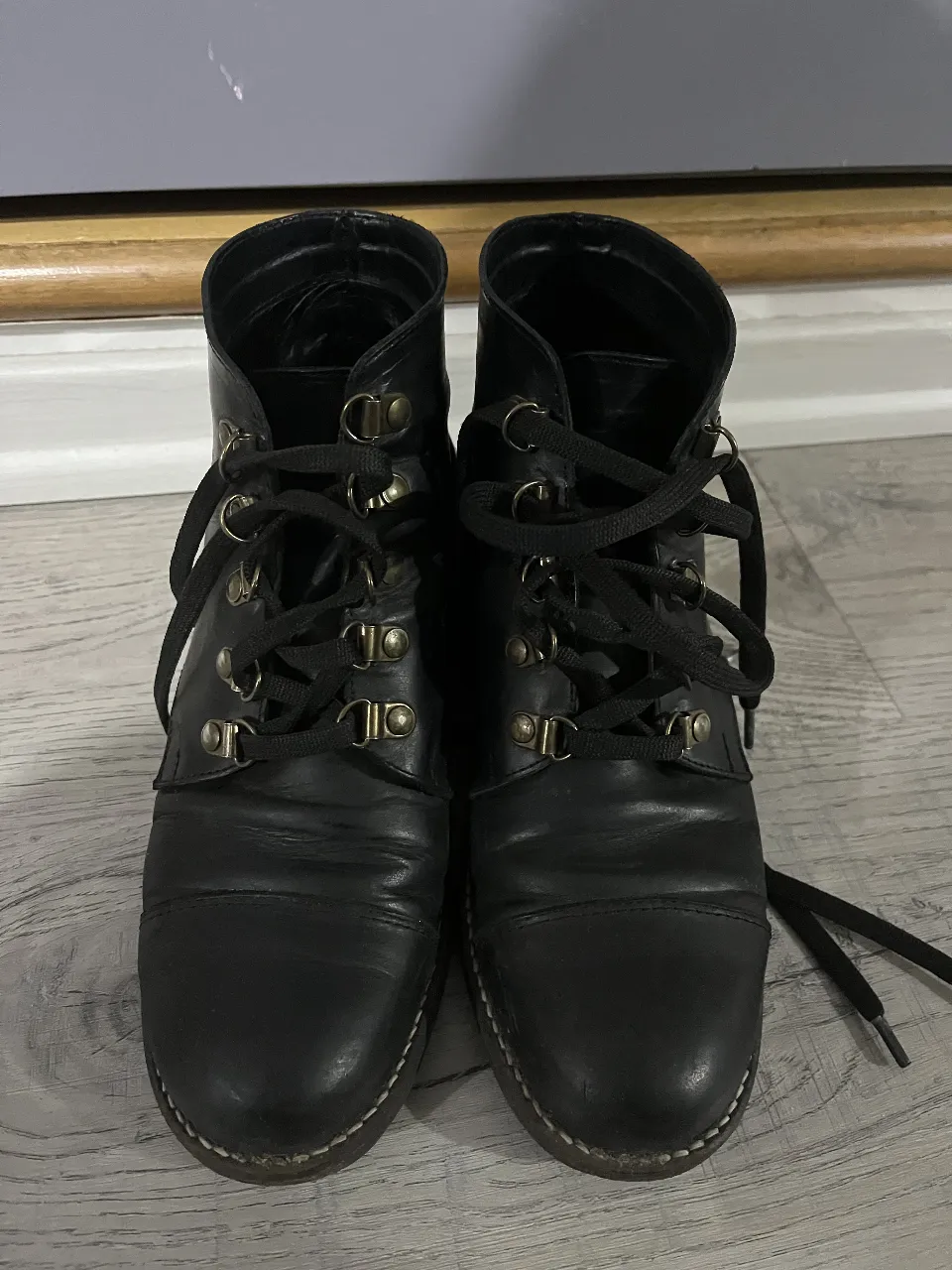 Botines negros de cuero con cordones y detalles metálicos. Ideales para un look casual y urbano.
