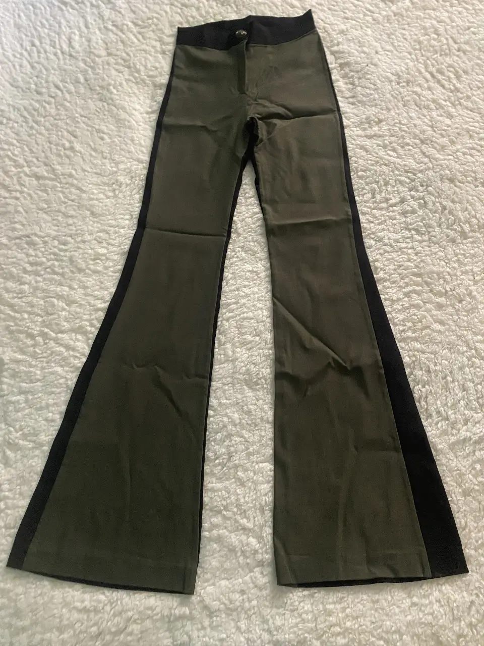 Pantalón sastrero de mujer, con diseño de campana y detalles en negro a los costados. Ideal para un look elegante y moderno.