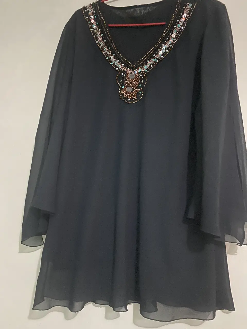 Vestido largo negro con detalles bordados en el cuello y mangas amplias. Ideal para eventos especiales o fiestas.