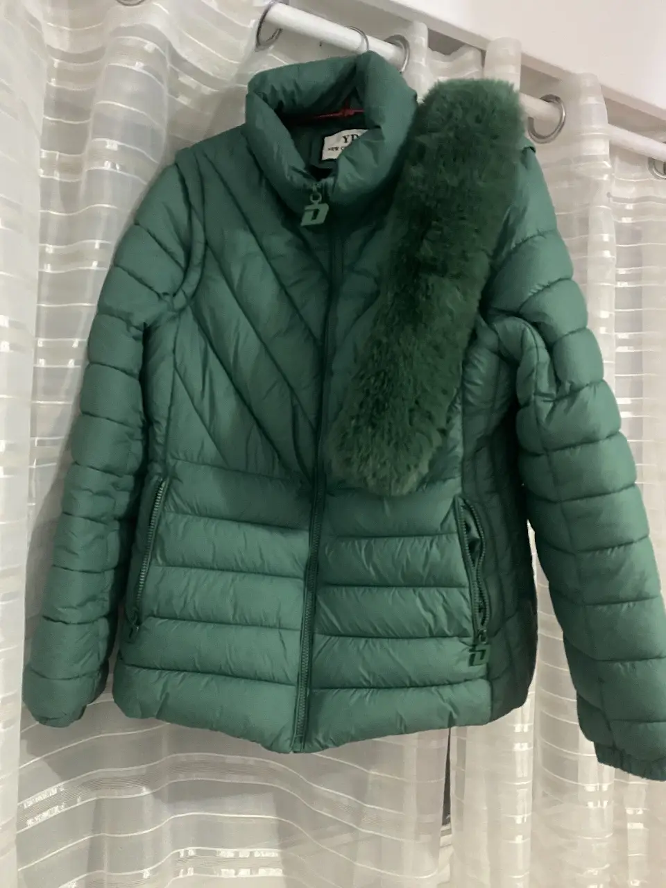 Campera de pluma verde, ideal para el invierno. Posee cierre y bolsillos con cierre. Incluye un cuello de piel sintética.