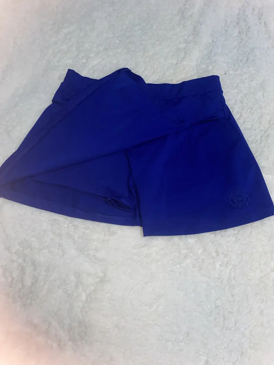Pollera deportiva azul, ideal para actividades físicas. Diseño con short interno para mayor comodidad y seguridad. Perfecta para running, tenis o cualquier entrenamiento.