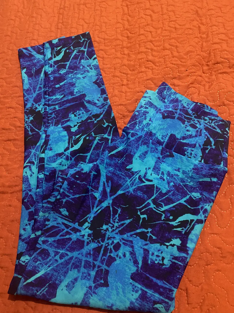 Calzas deportivas para mujer con estampado abstracto en tonos azules y negros. Ideales para actividades de fitness y entrenamiento. Diseño moderno y cómodo.