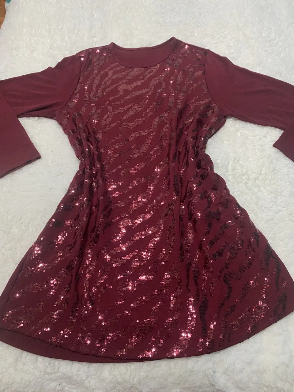 Vestido mini de fiesta en color bordó con lentejuelas en la parte delantera y mangas largas. Ideal para eventos especiales.
