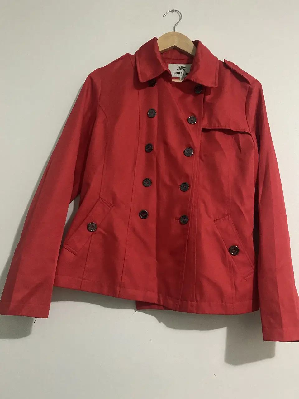 Campera roja de la marca Burberry London, estilo bomber, con botones y detalles en los hombros. Talle L