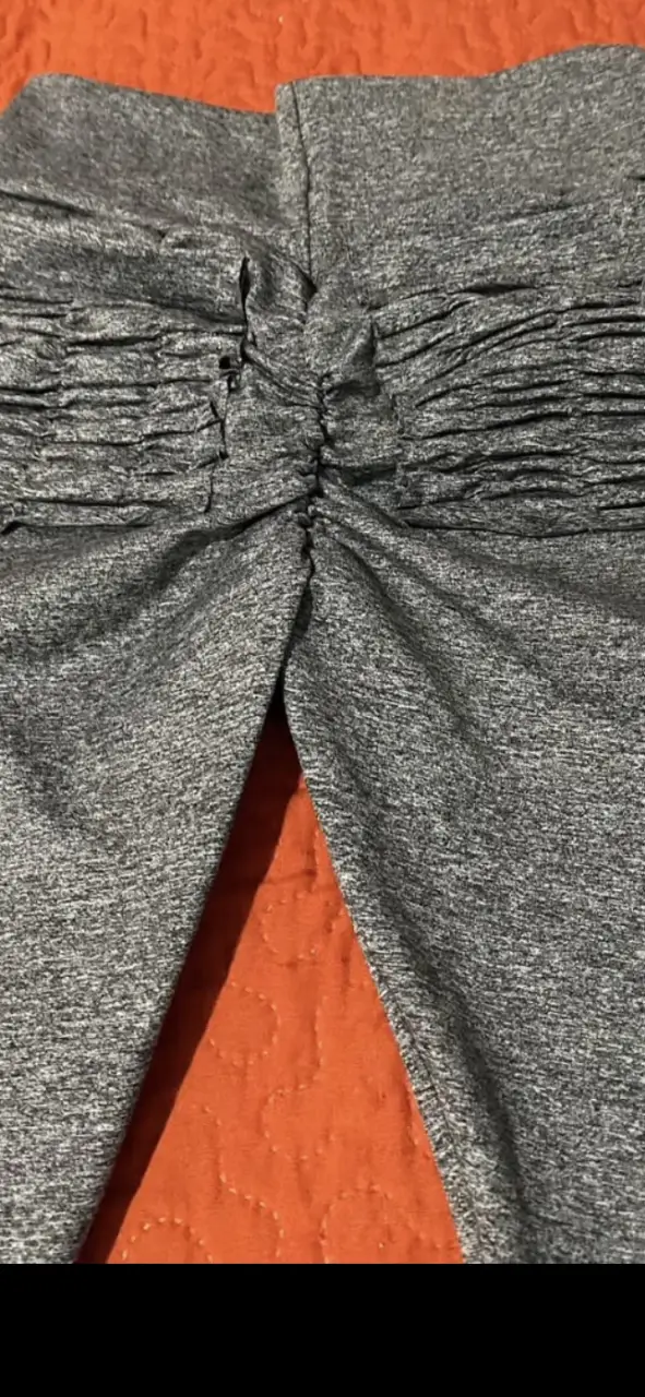 Calza deportiva de mujer, color gris jaspeado, con fruncido en la zona de los glúteos para realzar la figura. Ideal para actividades físicas y uso diario.