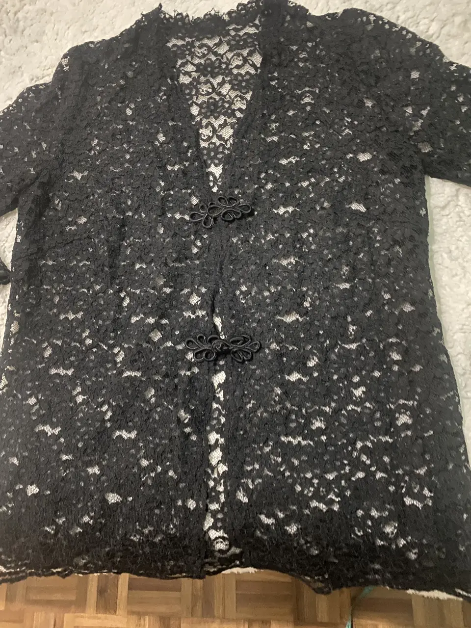Blusa de encaje negro con detalles de botones. Ideal para un look elegante y sofisticado.