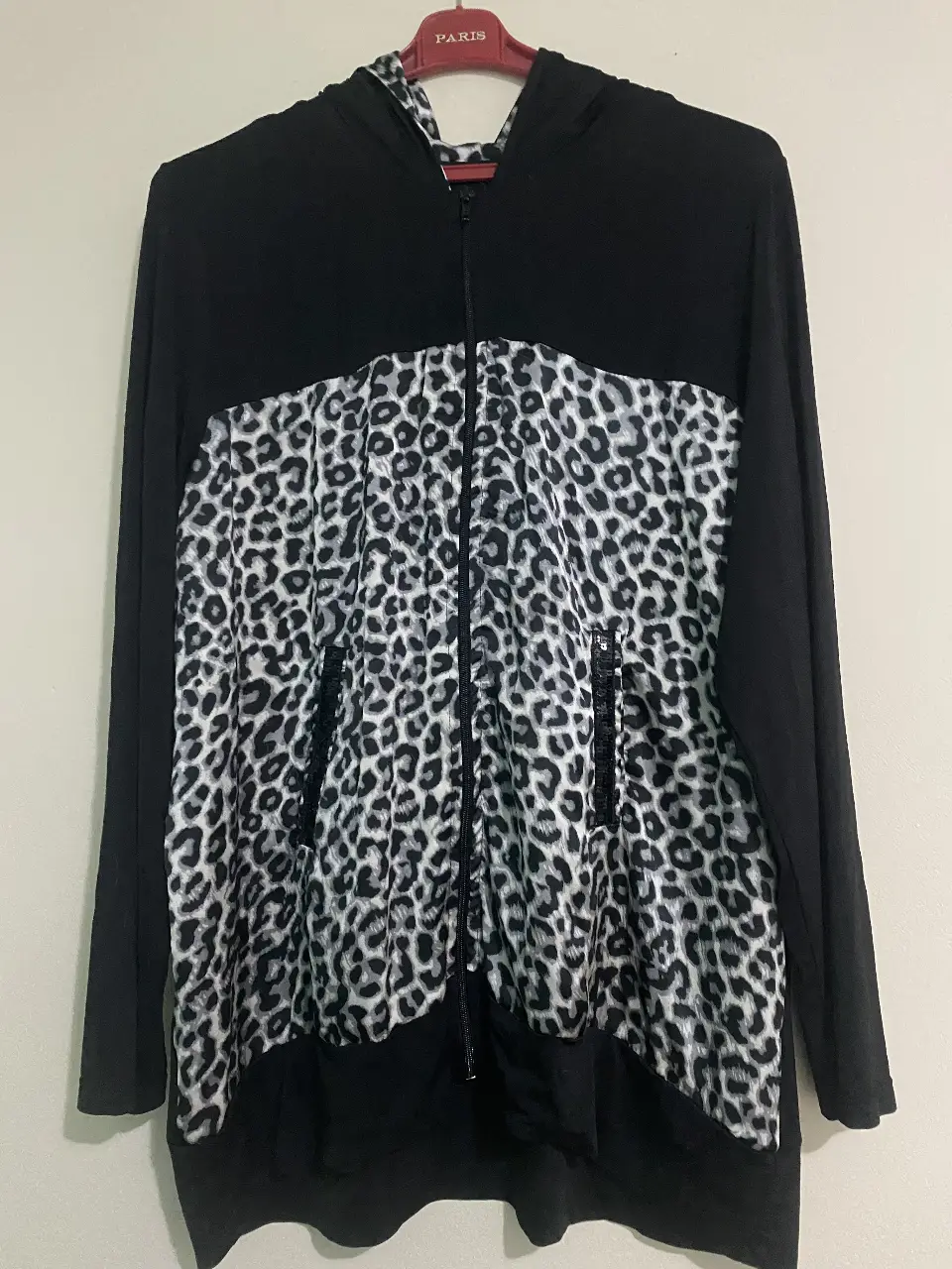 Buzo con cierre y capucha para mujer. Diseño con estampado de leopardo en la parte delantera y capucha, mangas negras. Detalles de lentejuelas en la cremallera.