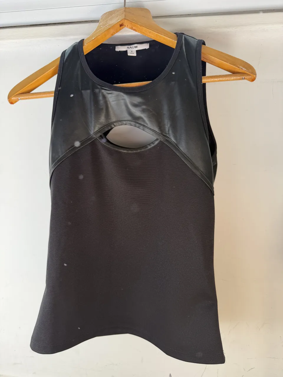 Musculosa negra con recortes en el frente y detalle de tela texturizada.